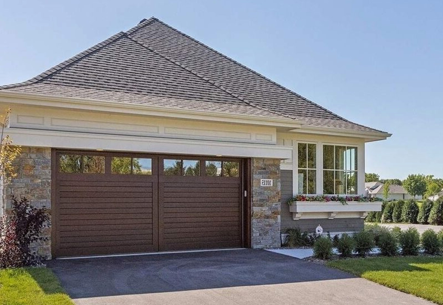 Villa exterior with layered gables, board-and-batten siding and a stone base