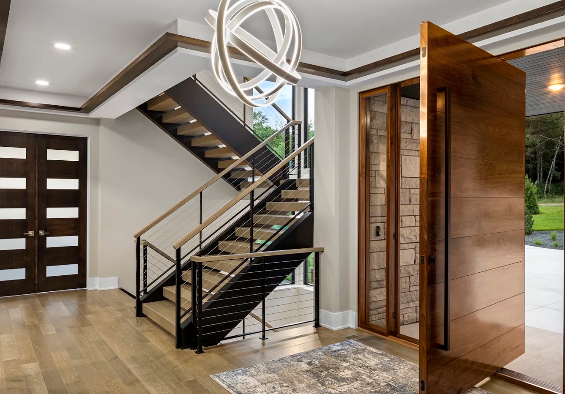 Entry hall with warm treads, a slender rail and natural light