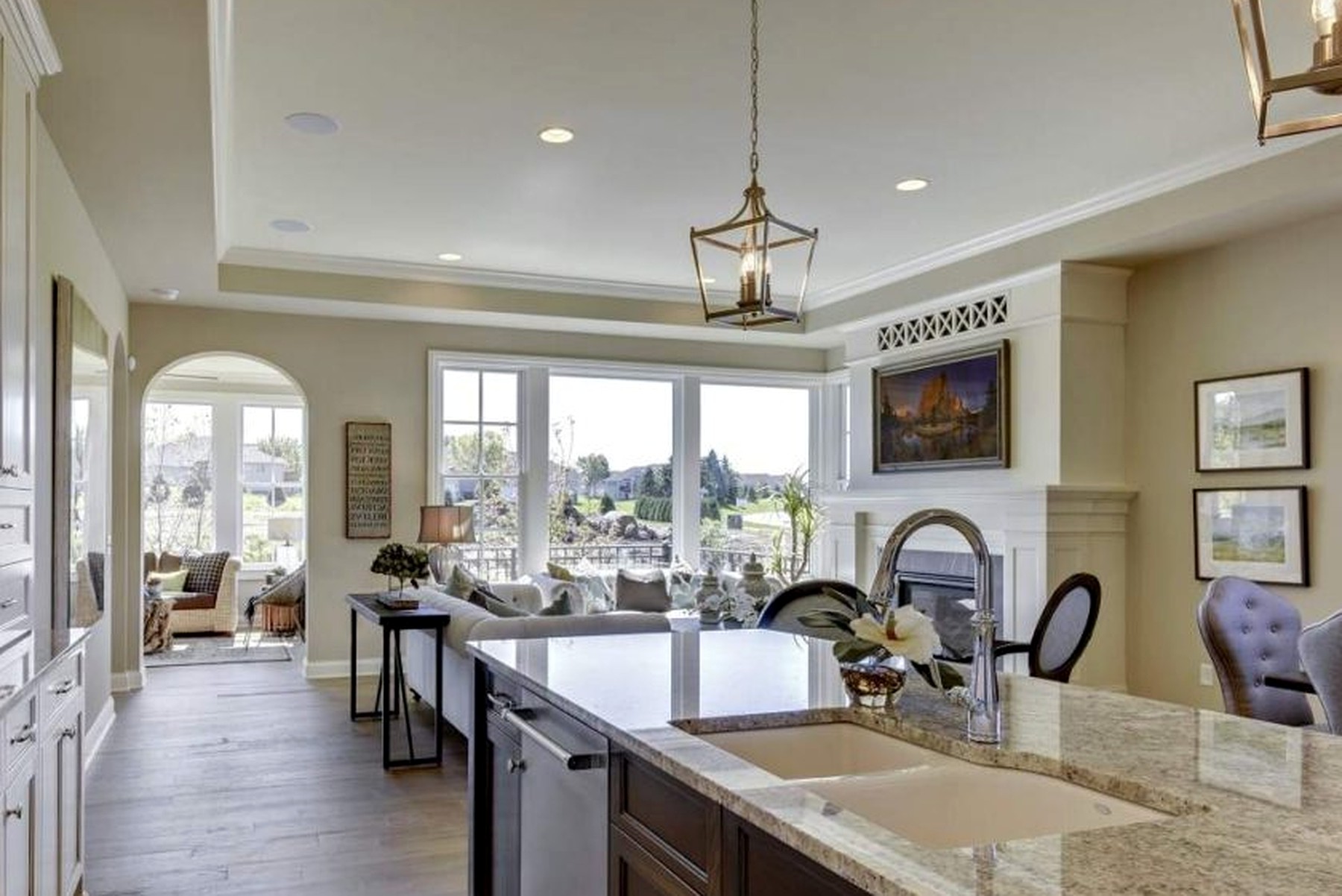 Kitchen island with an undermount sink opening to the great room and sunroom beyond
